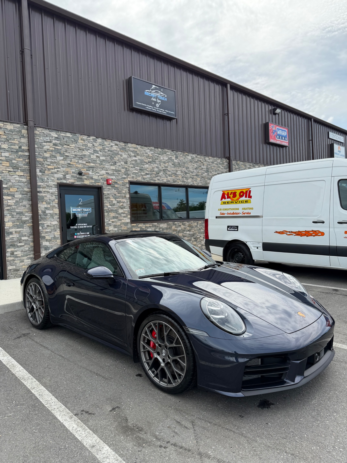 Porsche 911 Carrera S blue at Secret Touch Auto Spa storefront Shrewsbury MA
