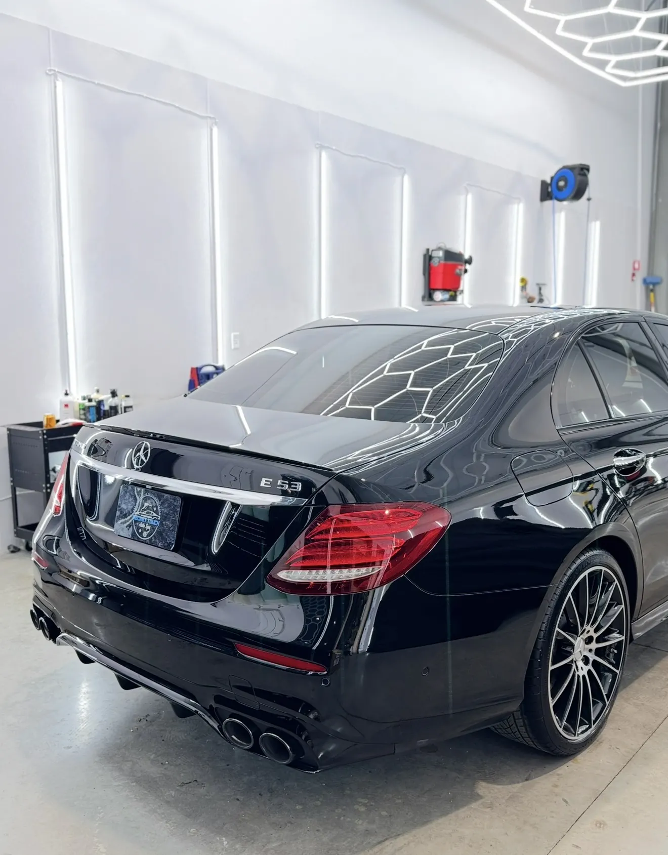 Black Mercedes-AMG E53 sedan after paint correction and ceramic coating outside in natural light at Secret Touch Auto Spa Shrewsbury MA