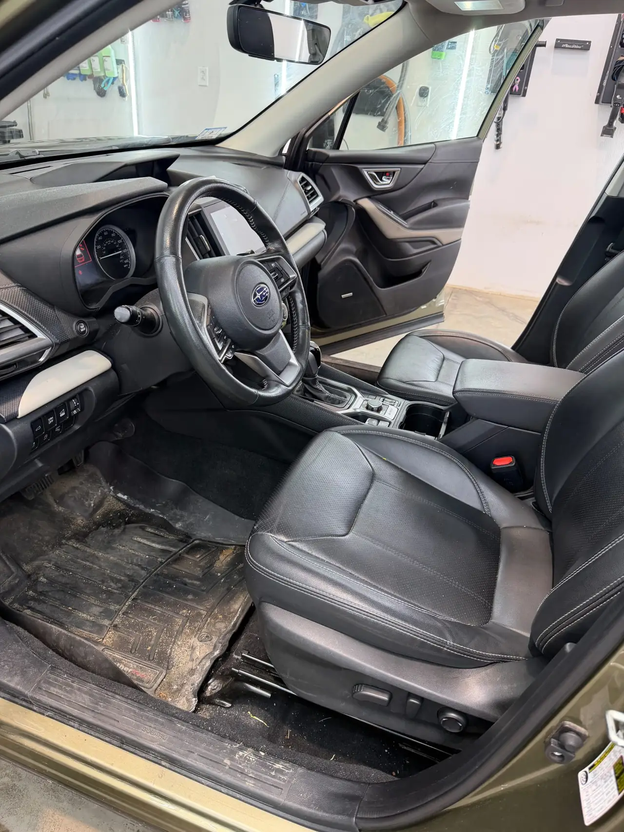 Subaru interior before professional detailing showing dirty floor mats and soiled carpet Shrewsbury MA